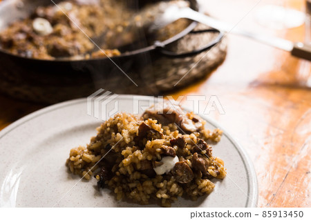 appetizing racy paella montana with mushrooms and pork trotters 85913450