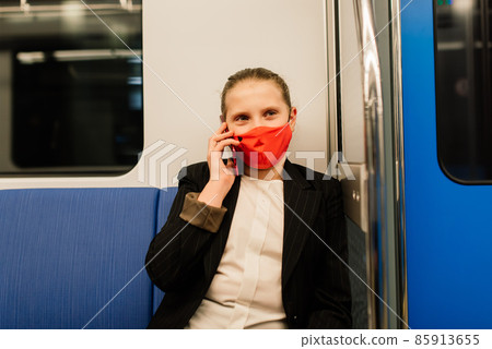 Nice pretty worried young girl wearing mask and headphones in a bus, train or metro going to school Nice pretty worried young girl wearing mask and headphones in a bus, train or metro going to school 85913655
