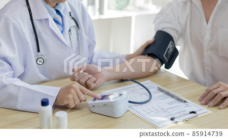 Male doctor uses a blood pressure monitor to check the body pressure and pulse of the patients who come to the hospital for check-ups, Medical treatment and health care concept. Male doctor uses a blood pressure monitor to check the body pressure and pulse of the patients who come to the hospital for check-ups, Medical treatment and health care concept. 85914739