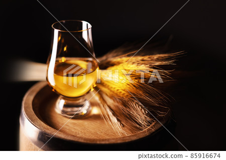A glass of whiskey on oak barrel 85916674