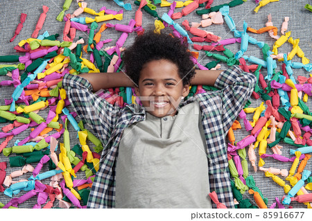 Happy adorable boy with toothy smile relaxing on the floor 85916677