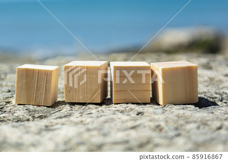 Wooden block on old tree stump with blurred background of ocean Wooden block on old tree stump with blurred background of ocean 85916867