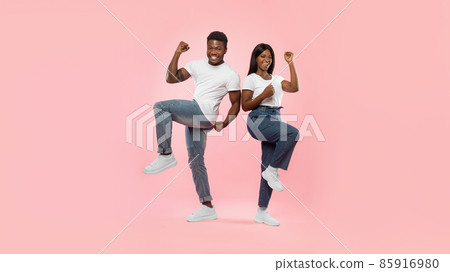 Portrait of excited young black couple shaking clenched fists Portrait of excited young black couple shaking clenched fists 85916980