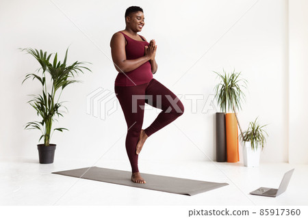 Happy fat black lady in sportswear attending online yoga class Happy fat black lady in sportswear attending online yoga class 85917360