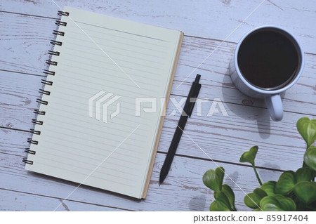 Directly view of notepad and pen with cup of coffee on wooden desk 85917404