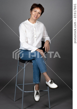 Mature woman posing on the chair Mature woman posing on the chair 85917601