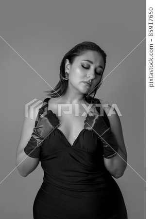 Half-length monochrome portrait of young beautiful woman posing isolated on gray studio background. Beauty, fashion, style, bodypositive concept 85917650