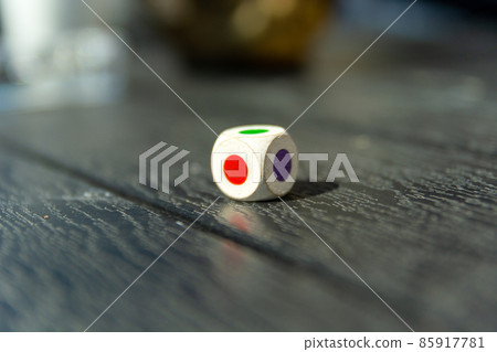 Dice with colored dots on the table 85917781