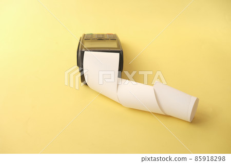 POS machine and long roll paper on yellow background  85918298