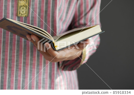 muslim man hand holding Holy book Quran with copy space  85918334