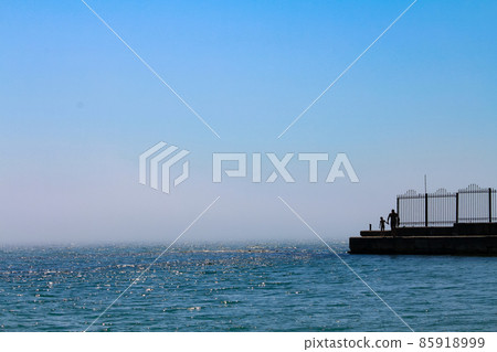 The sea silhouettes of people on the horizon, a blurred horizon in the fog 85918999