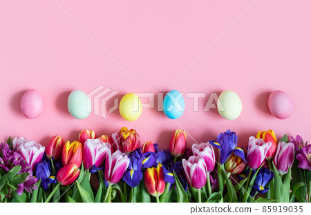 Beautiful Easter border with spring flowers and eggs on a pink background. Easter floral background. Copy space, top view, flat lay. Beautiful Easter border with spring flowers and eggs on a pink background. Easter floral background. Copy space, top view, flat lay. 85919035