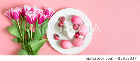 Easter holiday pink table setting with eggs, rabbit and a bouquet of tulips. Banner. Copy space, top view. Easter holiday pink table setting with eggs, rabbit and a bouquet of tulips. Banner. Copy space, top view. 85919037