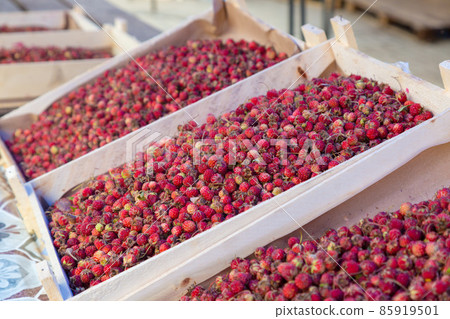 A box of big red juicy strawberries sold at the market in the city A box of big red juicy strawberries sold at the market in the city 85919501