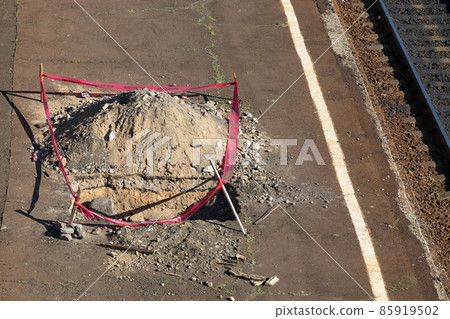 A pit surrounded by a red ribbon on the railway tracks near the station A pit surrounded by a red ribbon on the railway tracks near the station 85919502