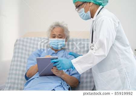 Doctor help Asian senior or elderly old lady woman patient wearing a face mask in hospital for protect safety infection and kill Covid-19 Coronavirus. Doctor help Asian senior or elderly old lady woman patient wearing a face mask in hospital for protect safety infection and kill Covid-19 Coronavirus. 85919992