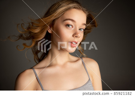 Close-up portrait of young beautiful girl with day makeup isolated over gray studio background. Natural beauty concept. 85921182