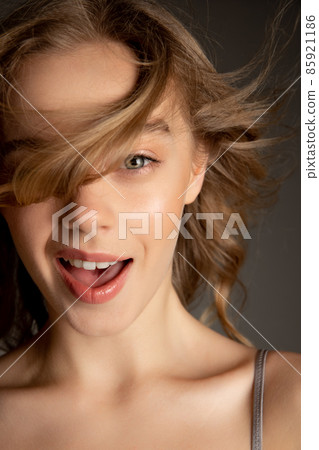 Close-up portrait of young beautiful girl with day makeup isolated over gray studio background. Natural beauty concept. Close-up portrait of young beautiful girl with day makeup isolated over gray studio background. Natural beauty concept. 85921186