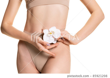 Beautiful body of young slim woman in nude color underwear isolated on light studio background. Natural beauty concept. Beautiful body of young slim woman in nude color underwear isolated on light studio background. Natural beauty concept. 85921208