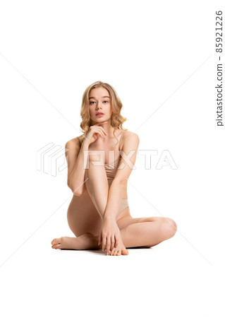 Young adorable woman in underwear sitting on floor isolated over white studio background. Natural beauty concept. Young adorable woman in underwear sitting on floor isolated over white studio background. Natural beauty concept. 85921226
