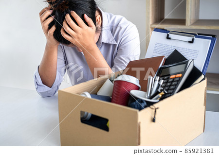 Images of business woman carrying packing up all his personal belongings and files into a brown cardboard box has frustrated and stressed to resignation and signing cancellation contract letter Images of business woman carrying packing up all his personal belongings and files into a brown cardboard box has frustrated and stressed to resignation and signing cancellation contract letter 85921381