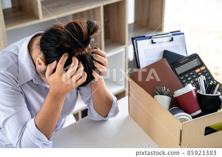 Images of business woman carrying packing up all his personal belongings and files into a brown cardboard box has frustrated and stressed to resignation and signing cancellation contract letter 85921383