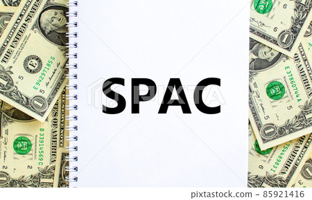 SPAC, special purpose acquisition company symbol. Words SPAC, special purpose acquisition company on white note on beautiful background from dollar bills. Business and SPAC vs IPO concept. Copy space. 85921416