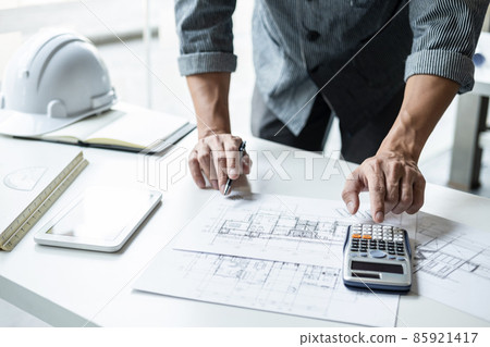 Architect working on blueprint, Engineer working with engineering tools for architectural project on workplace, Construction concept - building project, blueprints, ruler and dividers 85921417