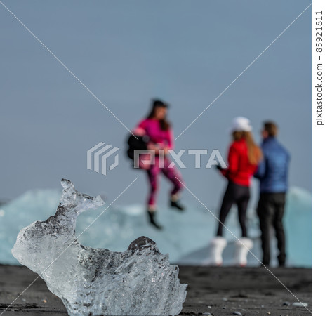 Blurred tourists in the background and iceberg in focus Blurred tourists in the background and iceberg in focus 85921811