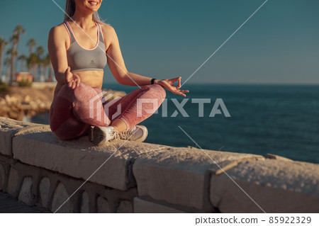 Sporty slender woman resting by the waterfront Sporty slender woman resting by the waterfront 85922329