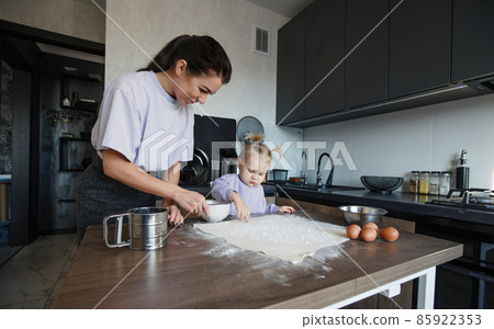 Happy loving family cooking bakery together. Mother and daughter-girl cook cookies and have fun in the kitchen. Homemade food and a little helper. 85922353
