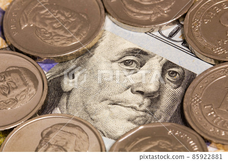 100 dollars banknote and white coins. A portrait of Roosevelt Franklin on a hundred dollar bill framed by silver coins. Money concept for financial and business news. Close-up 100 dollars banknote and white coins. A portrait of Roosevelt Franklin on a hundred dollar bill framed by silver coins. Money concept for financial and business news. Close-up 85922881