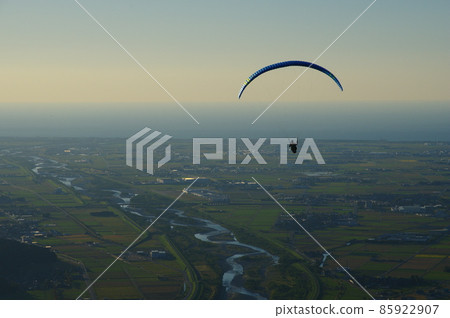 View of paraglider and Tedori River alluvial fan flying from Shishiku Highland in the evening View of paraglider and Tedori River alluvial fan flying from Shishiku Highland in the evening 85922907