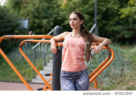 Confidence athletic woman standing sport ground in summer park looking away Caucasian sportive beautiful female portrait Confidence athletic woman standing sport ground in summer park looking away Caucasian sportive beautiful female portrait 85922997