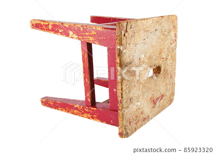 Old wooden stool with peeling red paint. Loft style chair isolated on a white background. 85923320