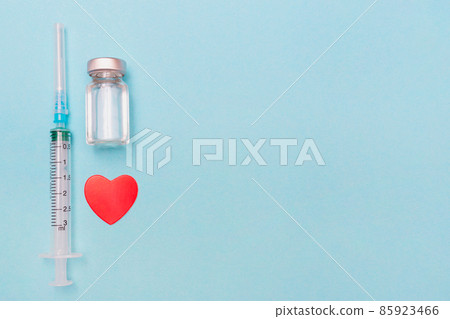 Syringe, heart, covid 19 vaccine and medical mask on a blue background. Keep your health. Vaccination. Medical treatment concept. Flat lay. Immunity. Copy space. Place for text. Syringe, heart, covid 19 vaccine and medical mask on a blue background. Keep your health. Vaccination. Medical treatment concept. Flat lay. Immunity. Copy space. Place for text. 85923466