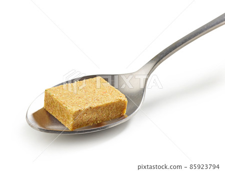 instant chicken broth cube in a spoon 85923794