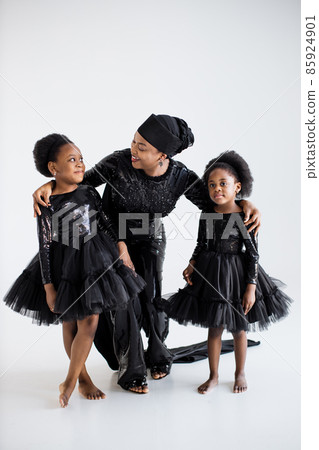 Mother and daughters in elegnat clothes posing indoors Mother and daughters in elegnat clothes posing indoors 85924901