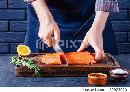 Man is cutting salmon fillet., top view Man is cutting salmon fillet., top view 85925010