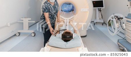 Doctor or nurse and patient with tomography CT or MRI Scan in hospital. Interior of radiography department. Technologically advanced equipment in white room. Magnetic resonance diagnostics machine. 85925043