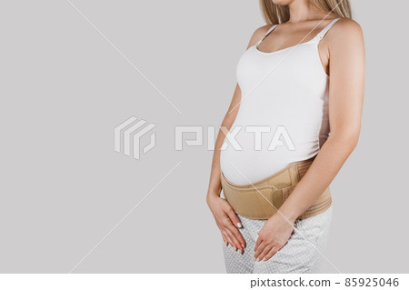 Pregnant woman belly in prenatal pregnancy maternity belt. Orthopedic abdominal support waist, back, abdomen band. Belly brace or band for pregnancy. Horizontal web banner. Torso of pregnant model. 85925046
