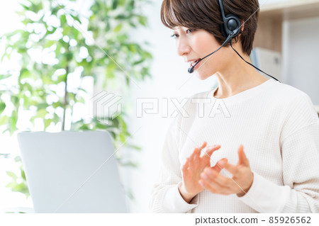 Middle-aged woman working remotely Middle-aged woman working remotely 85926562