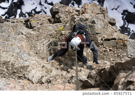 Climber is rappeling from the mountains summit. Climber is rappeling from the mountains summit. 85927551