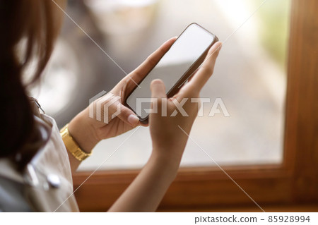 Female using smartphone at cafe, smartphone blank screen mockup. Female using smartphone at cafe, smartphone blank screen mockup. 85928994