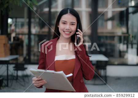Smiling and happy asian businesswoman talking with mobile phone. Finance and Accounting concept. Smiling and happy asian businesswoman talking with mobile phone. Finance and Accounting concept. 85929912