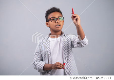 Cute boy in eyeglasses concentrated on his thoughts Cute boy in eyeglasses concentrated on his thoughts 85932274