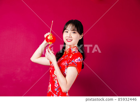 Pretty girl in red cheongsam on red background 85932446
