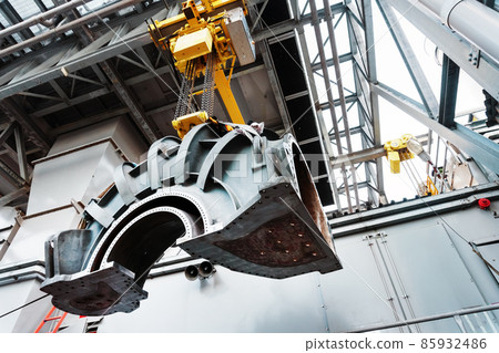 Part of the turbine compressor housing is suspended on a crane. Part of the turbine compressor housing is suspended on a crane. 85932486
