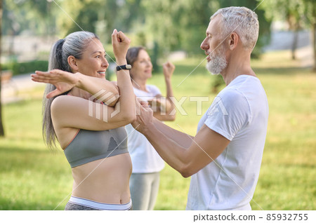 Male instructor checking the correctness of the exercise 85932755