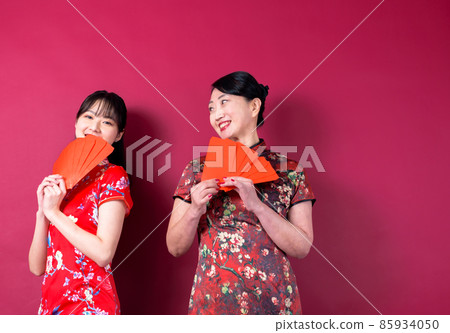 在紅色背景中賀年的母女 在紅色背景中賀年的母女 85934050